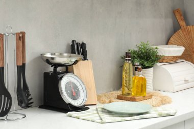 Retro mechanical kitchen scale and other utensils on white countertop indoors
