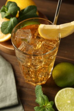 Buzlu çayı limon dilimi, kireç ve nane şekeri ile ahşap masada tazeliyorum. Yakın plan.