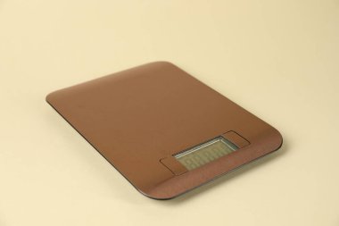 One electronic kitchen scale on beige background, closeup