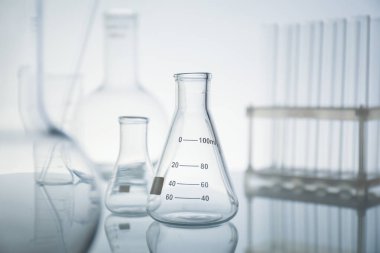 Ayna yüzeyinde ışık arkaplanına karşı laboratuvar camları