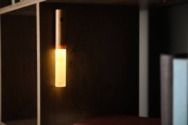 İçerideki rafta parlayan modern LED lamba, yakın plan