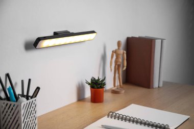 Modern LED lamp on wall above desk, closeup