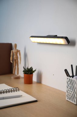 Modern LED lamp on wall above desk, closeup