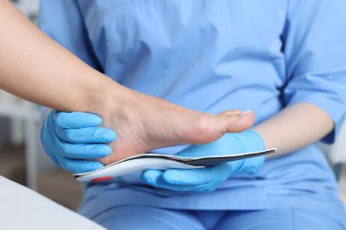 Hastanedeki hastanın ayağına taban takan doktor, yakın plan.