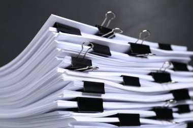 Gri arkaplan üzerine kağıt sayfaları ile cilt ataçları, yakın plan