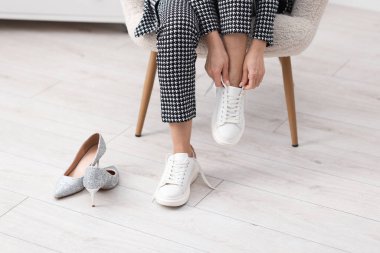 Kadın ayakkabılarını içeride değiştiriyor, yakın plan.