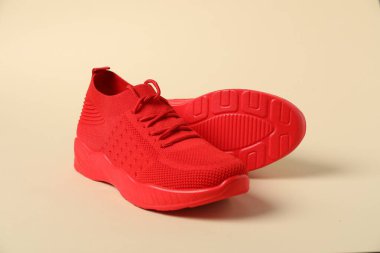 Bej arka planda kırmızı spor ayakkabılar. Spor ayakkabılar.