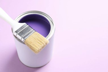 Mor arka planda parlak boya ve fırça kutusu, yakın plan. Metin için boşluk