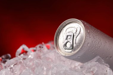 Koyu kırmızı arka planda buz kalıplarındaki içecekler tazeleniyor. Yakın plan.