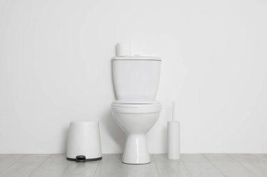 Beyaz duvarın yanında tuvalet, fırça ve ihtiyaçlar