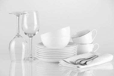 Açık arkaplanda farklı temiz bulaşık takımı ve çatal bıçak takımı