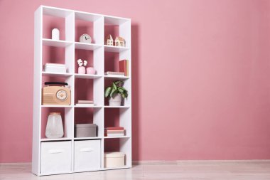 İçeride pembe duvarın yanında dekorasyonu olan raf ünitesi. Metin için boşluk