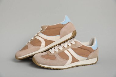 Açık gri arka planda şık bir çift spor ayakkabı. Sıradan ayakkabılar.