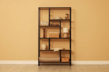 Shelving unit with decor near beige wall indoors
