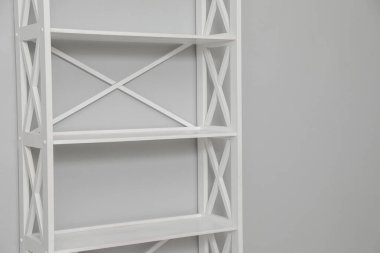 Açık gri duvarın yanındaki boş raf ünitesi