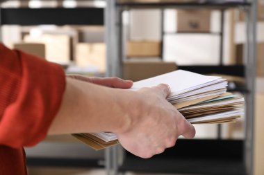 Postanede bir sürü farklı zarfı olan kadın, yakın plan.