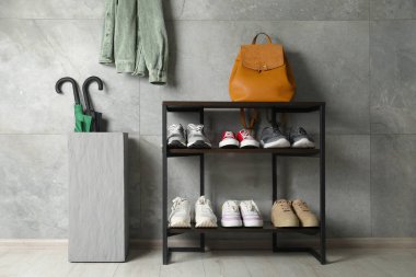 Ayakkabı deposu. Farklı ayakkabı, sırt çantası ve şemsiyeli raf ünitesi.