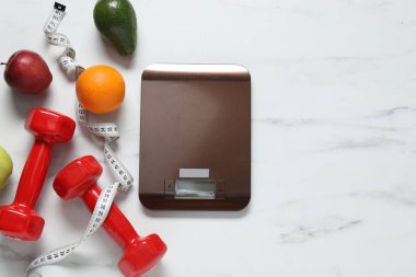 Elektronik mutfak ölçeği, mezura, halterler ve ürünler beyaz mermer masa üzerinde, düz zemin. Metin için boşluk
