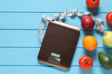 Elektronik mutfak ölçeği, mezura ve açık mavi ahşap masa üzerindeki ürünler, düz yatak. Metin için boşluk