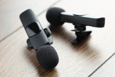 Lavalier mikrofonları ahşap masada, yakın plan. Ses ekipmanları