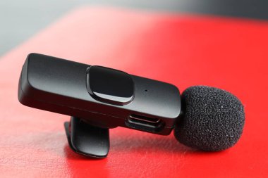 Lavalier mikrofonu kırmızı deftere, yakın plan. Ses ekipmanları