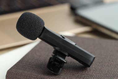 Lavalier mikrofon ve defter masanın üstünde, yakın plan.