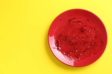 Sarı arka planda kirli bir tabak, üst manzara.