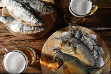 Kurutulmuş balık ve bira bardakları ahşap masada, düz yatıyordu.