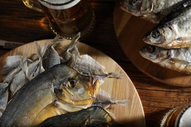Kurutulmuş balık ve bira bardakları ahşap masada, düz yatıyordu.