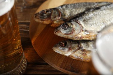 Kurutulmuş balık ve bira ahşap masada, yakın plan.