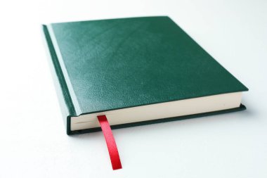 Beyaz masa üzerinde kırmızı kurdele yer imi olan kitap, yakın plan