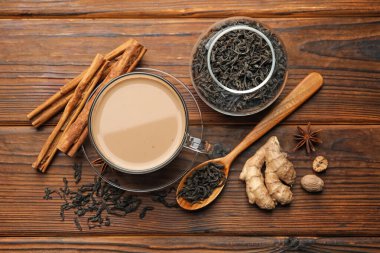 Fincanda Aromatik Masala çayı, ahşap masada baharatlar ve kuru yapraklar.