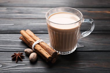 Cam bardakta Aromatik Masala çayı ve ahşap masada baharatlar, yakın plan.