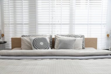 Şık bir odada yumuşak çarşafları olan rahat bir yatak, yakın çekim. İç tasarım