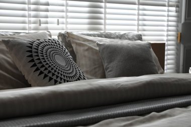 Şık bir odada yumuşak çarşafları olan rahat bir yatak, yakın çekim. İç tasarım