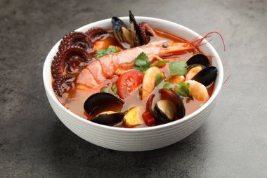 Gri desenli masada kasede lezzetli deniz ürünleri çorbası, yakın plan.