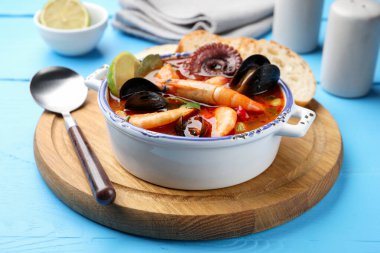 Lezzetli deniz ürünleri çorbası mavi ahşap masada, yakın plan.