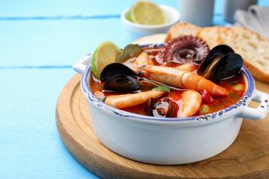 Lezzetli deniz ürünleri çorbası mavi ahşap masada, yakın plan.