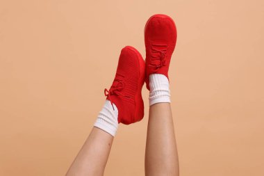 Bej arka planda şık ayakkabılar giyen kadın, yakın plan.