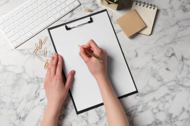 Beyaz mermer masadaki panoya yazı yazan kadın, üst görünüm