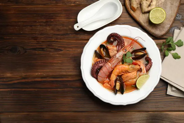 Ahşap masada servis edilen nefis deniz ürünleri çorbası. Metin için boşluk