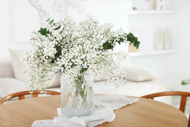 Güzel çigila çiçekleri ve okaliptüs dallarıyla dolu bir vazo.