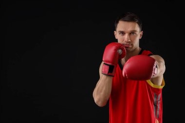 Siyah arka planda dövüşen boks eldivenli adam, metin için boşluk