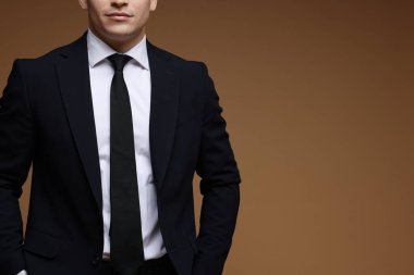 Kahverengi arka planda klasik takım elbiseli adam, yakın plan. Metin için boşluk
