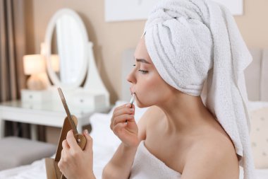 Güzel bir kadın evde cımbızla bıyığını koparıyor.