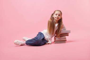 Pembe arka planda bir sürü kitabı olan liseli kız.