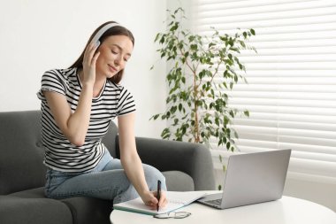 İçerideki masada ders sırasında not alan bir kadın. Kendi kendine çalışma.