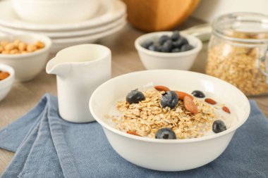 Sütlü yulaf ezmesi, yaban mersini ve badem tabakta, yakın plan.