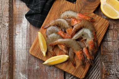 Tahta masada taze çiğ karides ve limon.