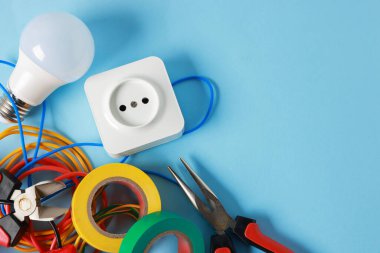 Açık mavi arka planda, düz zeminde farklı elektrikli aletler. Metin için boşluk